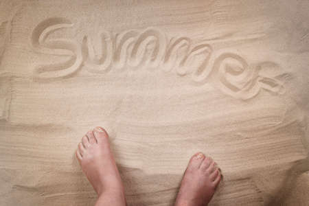 Summer inscription on sandy beach, personal point of view.の写真素材
