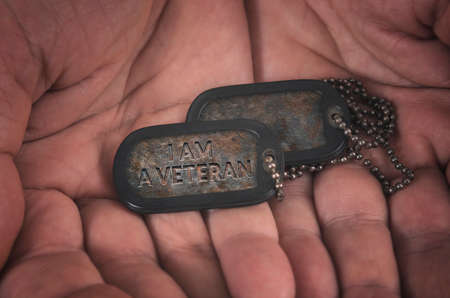 I am veteran military dog tag in mans hands.の写真素材