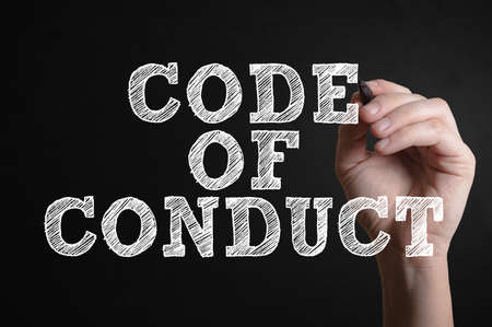 Hand writing Code of conduct on a virtual screenの写真素材