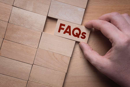FAQs word written on wooden block. Frequently Asked Questions concept.の写真素材