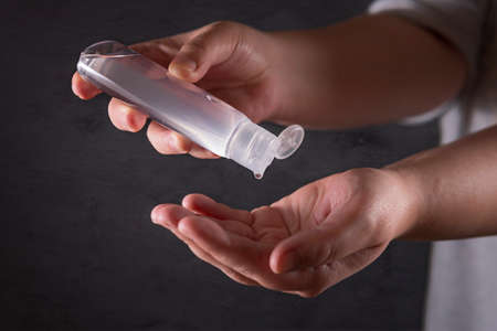 Wash your hands. Woman sanitizing hands with alcohol gel cleaner.の写真素材