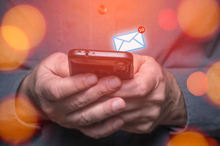 Businessman using a smart phone device to receive an e-mail message.の写真素材