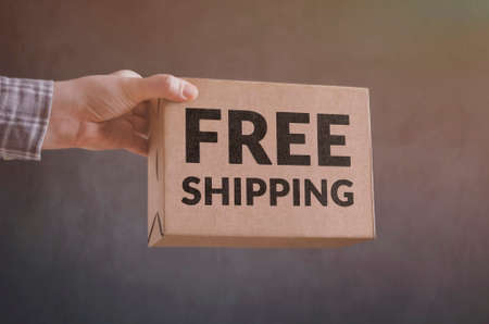 Deliveryman gives Free Shipping carton box. Free shipping business concept.の写真素材