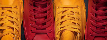 Diversity. Red and yellow sneakers standing by each other depicting the idea of diversity, unity and inclusion.の写真素材