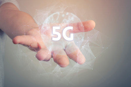 5G network wireless systems and internet of things with open palm hand gesture of male hand on light...