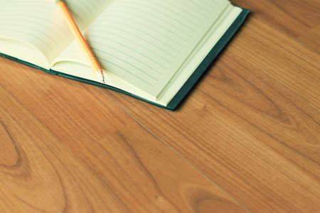 Vintage style of open notebook and pen on the old wooden floor.の写真素材
