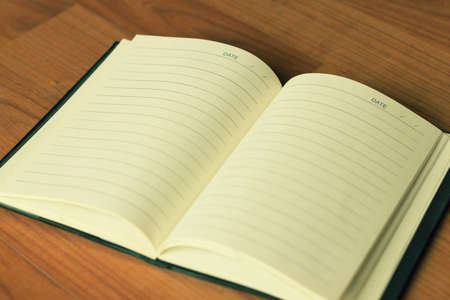 Vintage style of open notebook on the old wooden floor.の写真素材
