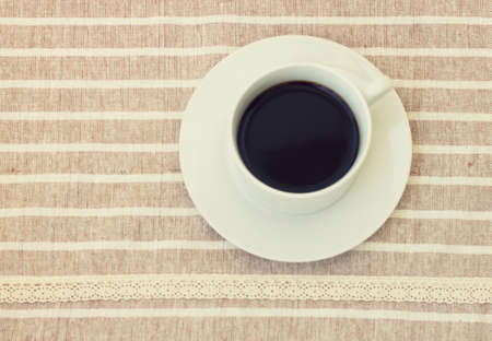 Vintage style of a cup of coffee on cute fabric. Top viewの写真素材