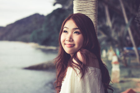 Pretty Asian woman feeling relaxed at the beach.の写真素材
