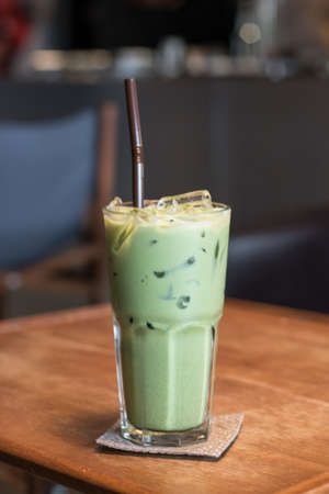 Iced Matcha latte tea on wooden tableの写真素材