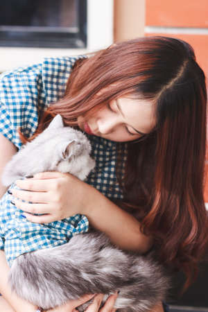 Close up of young Asian woman playing with her persian cat, human-animal relationships.の写真素材