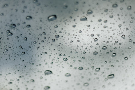 Blurred rainy window with red bokeh light
