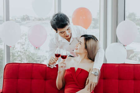 Young Asian couple celebrating new year together, drinking wine together.の写真素材