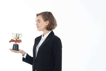 Portrait of successful business woman hoding trophy on white isolated background.の写真素材