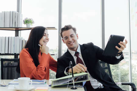 Two business people discussing about work in an office.の写真素材