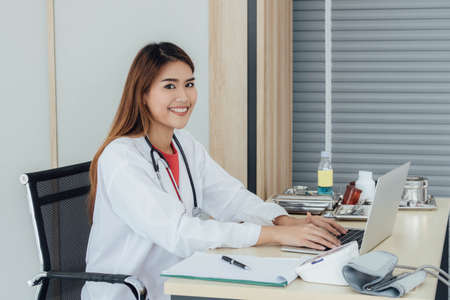 Young Asian doctor working on her desk.の写真素材