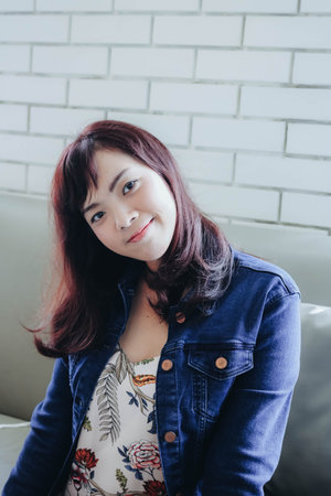 Young pretty Asian woman sitting in the cafe with nature light.
