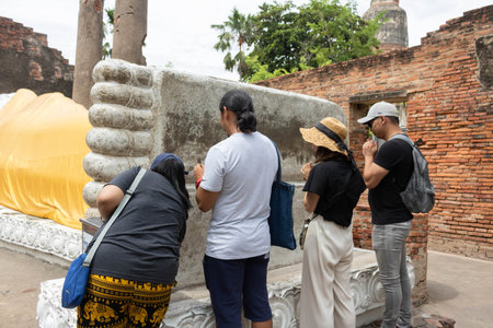 THAILAND - AUG 29, 2019 : A group of tourists make merit at a temple in Ayuttaya, Thailand.のeditorial素材