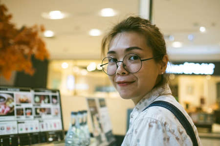 Closeup of young Asian woman with blur shopping mall background.の写真素材