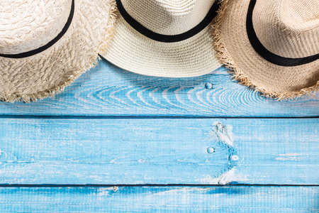 Straw hats on light blue wooden background, beach and Summer concept.の写真素材