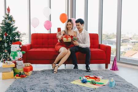 Young Asian couple is using phone to take selfie together, Valentine's day concept.