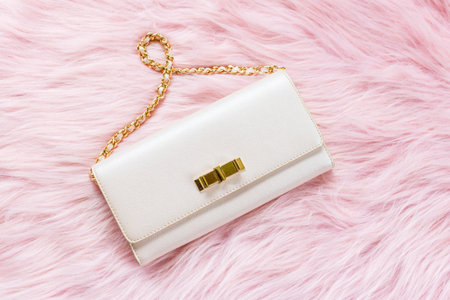 Luxury pink clutch bag on a fur pink background.