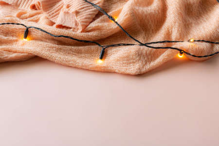 Pink cardigan with fairy lights on a pink background.の写真素材