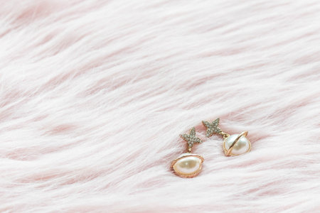 Luxury earrings on the pink fabric with copy space.