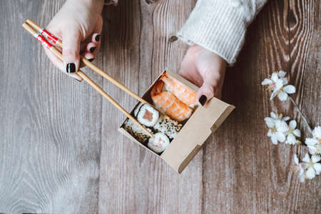 Top view of man taking photo of sushi on the white table. Social networking and take-away conceptの写真素材