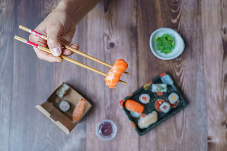 Top view of man taking photo of sushi on the white table. Social networking and take-away conceptの写真素材
