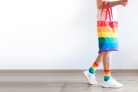 Unrecognizable young man posing dressed in socks and rainbow bag. Concept of freedom, LGBTQ +.