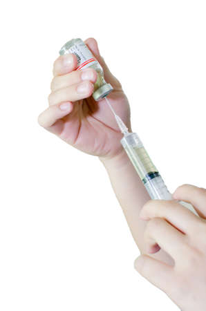 Syringe with a medicine in a female hands, isolated on whiteの写真素材