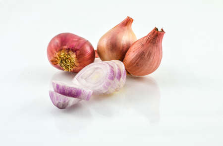 Whole and slices of shallots on white background の写真素材