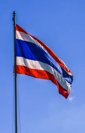 Flag of Thailand atop a background blue sky の写真素材