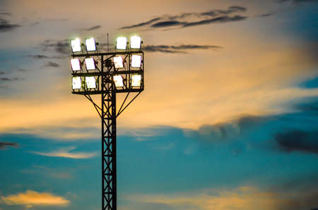 Pillar spotlights football field in the background blue sky at sunset の写真素材