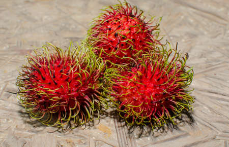 Fresh rambutan fruit from Thailand tropical gardens on the wooden floor の写真素材