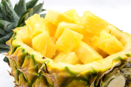 Cubed pineapple presented in its own bowl on white background の写真素材