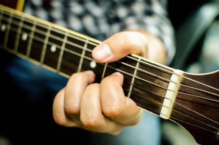 Acoustic guitar being played, Fingers holding a chord の写真素材