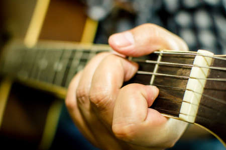 Acoustic guitar being played, Fingers holding a chord の写真素材