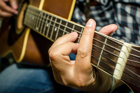 Acoustic guitar being played, Fingers holding a chord の写真素材