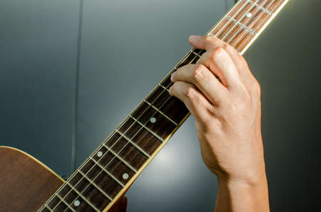 Acoustic guitar being played, Fingers holding a chord.の写真素材