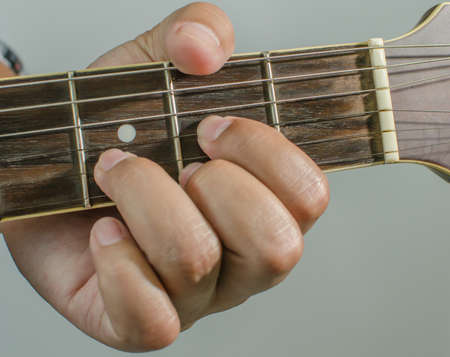 Acoustic guitar being played, Fingers holding a chord.の写真素材