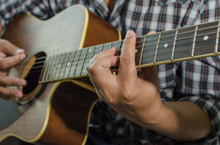 Acoustic guitar being played, Fingers holding a chord.の写真素材