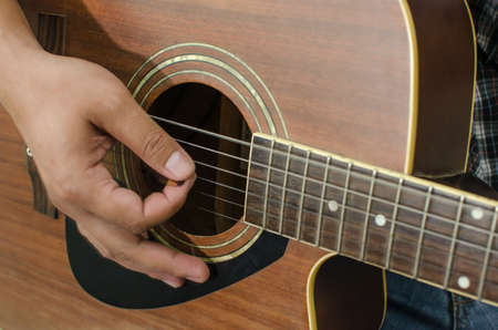 Acoustic guitar being played, Fingers holding a chord.の写真素材