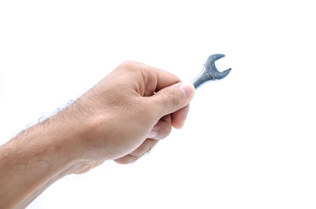 Hand with a new wrench isolated on white