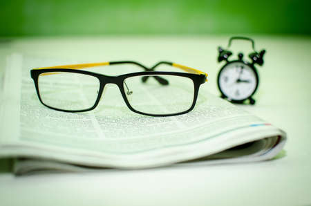 Stack of newspapers   glasses on table の写真素材