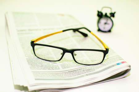 Stack of newspapers   glasses on table の写真素材