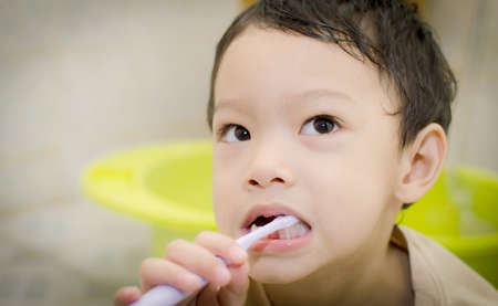 Young boy brushing his teeth; 3 years oldの写真素材