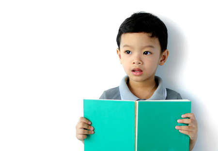 Cute little boy reading a book on white backgroundの写真素材