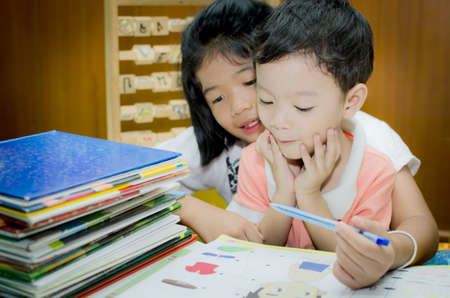 Sister helping brother to writing homeworkの写真素材